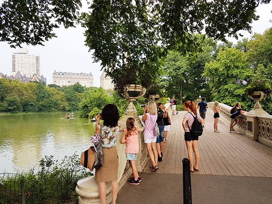Turistas fotografiando The Pond desde Bow Bridge en Central Park - Foto de AHM