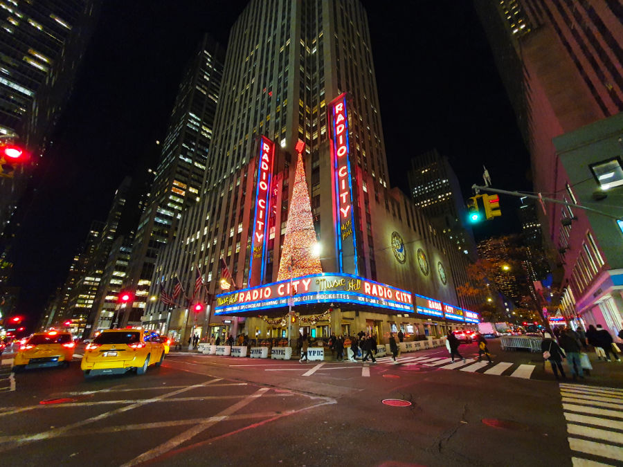 Panorámica del edificio del Radio City Music Hall en Navidad. Se ve el enorme árbol de Navidad iluminado sobre su marquesina y en la marquesina se anuncia su Musical de Navidad "Christmas Spectacular" con las Rockettes. Foto de Andrea Hoare Madrid