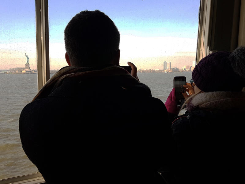 Turistas fotografiando la Estatua de la Libertad desde el ferry anaranjado a Staten Island - Foto de Andrea Hoare Madrid