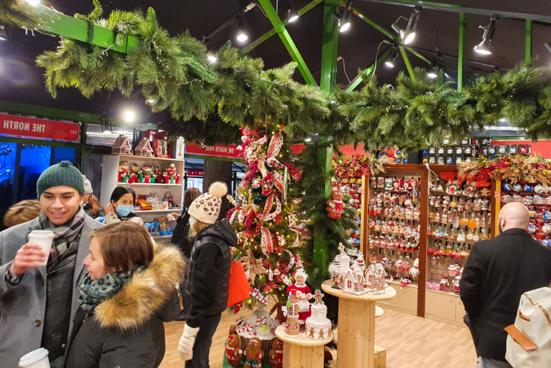 Personas dentro de una tienda de regalos de Navidad en la Feria Navideña de Bryant Park, uno de los mercadillos navideños clásicos de Manhattan - Foto de Andrea Hoare Madrid