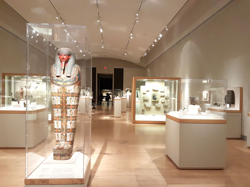 Vista general de una de las salas de la Colección de Antigüedades Egipcias del Museo de Brooklyn, en primer plano se ve un sarcófago de pie. Foto de Andrea Hoare Madrid