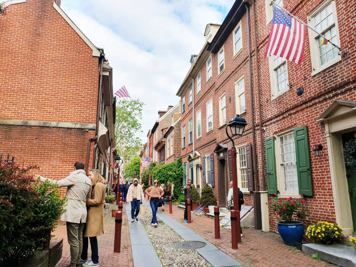 Turistas caminando por el Callejón Elfreth -Elfreth's Alley- en Filadelfia, la calle colonial mejor conservada de los Estados Unidos, la que ha sido habitada continuamente por más de 300 años. Foto de Andrea Hoare Madrid