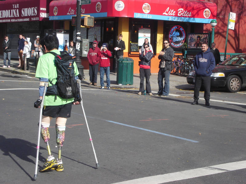 Personas aplaudiendo a un atleta con prótesis en sus piernas, durante la carrera del Maraton de la ciudad de New York - Foto de Andrea Hoare Madrid