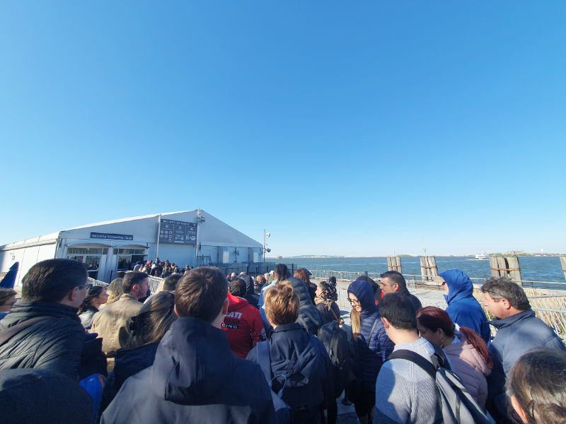 Galpón para el chequeo de seguridad para visitar Liberty Island, filas de personas esperando en el exterior del recinto - Foto de Andrea Hoare Madrid