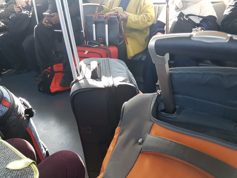 Personas viajando en el Airtrain desde JFK con maletas. Foto de Andrea Hoare Madrid